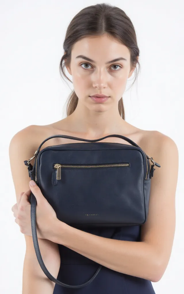 A French female model with a Zip   top bag, wearing a dress, against a white background, in a front   facing close   up